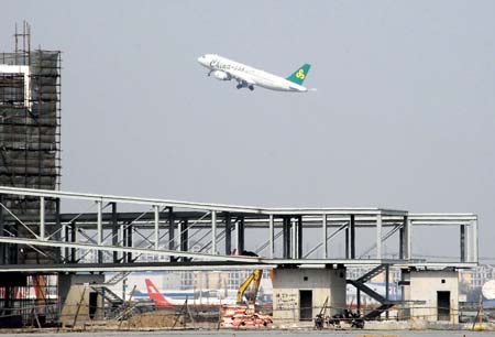 A jumbo jet takes off overhead the Boarding Corridor connecting the Terminal No. 2, of the Hongqiao Airport, in Shanghai, east China, April 8, 2009. Shanghai built the new terminal to cater to the continuous growth of passenger and cargo flows in and out of the most populous city on China's east coast, well prepared for the Shanghai World Expo 2010 which is expected to bring large increase in air passenger traffic. (Xinhua/Niu Yixin)