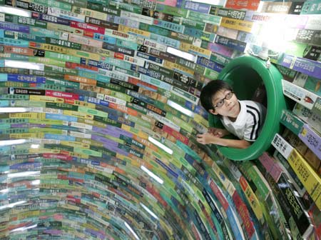 A child looks inside a tunnel made out of books during the "Diversity of Taiwan 2006" exhibition in Taipei, July 30, 2006. [Reuters]