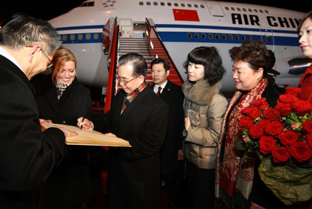 Chinese Premier Wen Jiabao (3rd, L) signs his autograph on the comment book of honored guests after he arrives at Copenhagen, capital of Denmark , on Dec. 16, 2009. Wen Jiabao arrived here Wednesday evening for the ongoing UN Climate Change Conference.