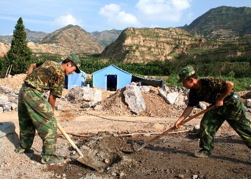 解放军帮助甘肃受灾群众重建家园 在甘肃省陇南市佛崖乡贾店村,来自兰州军区某红军师金刚钻团的战士在混合水泥(7月29日摄)。目前,甘肃省地震灾区全面进入灾后重建阶段,来自兰州军区的解放军官兵深入受灾村镇修公路、建房屋,积极帮助受灾群众重建家园。 新华社记者 卫韦华 摄