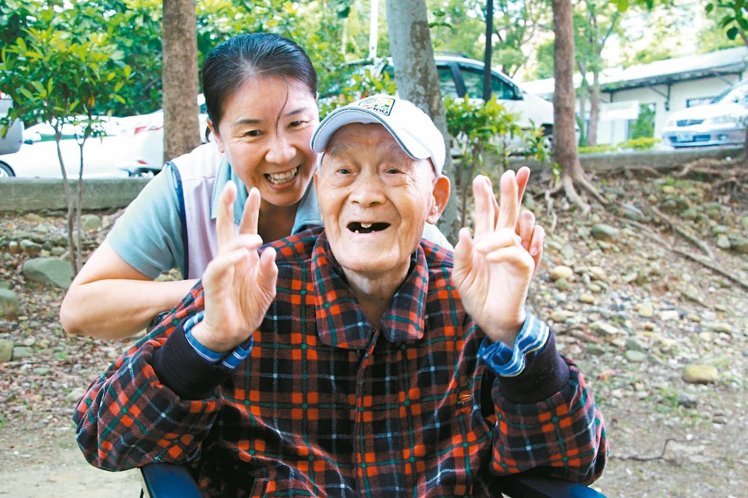 115岁杨之干，个性随和又爱笑，看护胡翠娥也喜欢和他相处。（《联合报》 陈雨鑫摄）