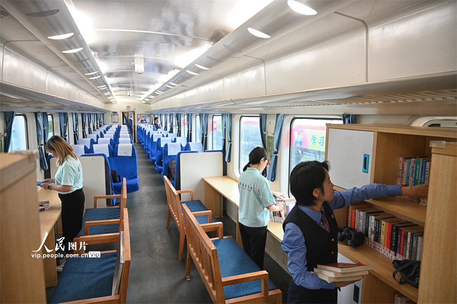 4月13日,秀山开往重庆北的5610次公益性“慢火车”3号车厢列车书屋,来自重庆客运段、重庆图书馆的志愿者们正在对列车书屋的图书做最后的调整。