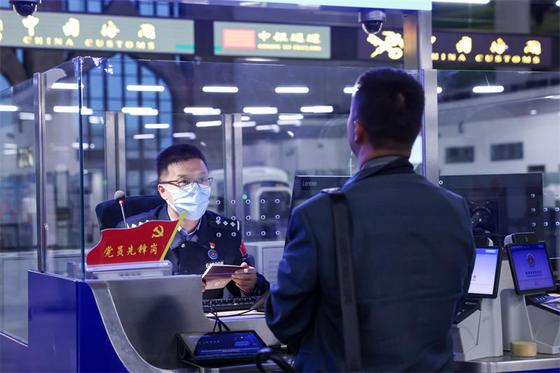 图为霍尔果斯出入境边防检查站民警为入境游客办理边检手续。宋唯一摄