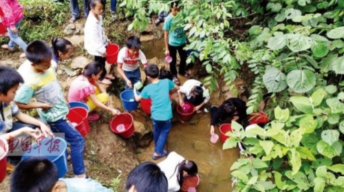 广西干旱致学校缺水 学生用杯子在山谷中舀水喝