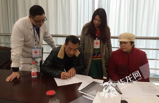 小月父親鄧師傅在登記表上簽字。 市紅十字會供圖 華龍網發
