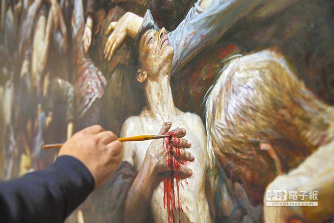 画家李子健正在对第三幅《南京大屠杀》油画作品做最后的修改