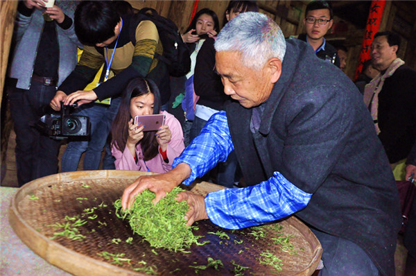 图为老师傅正在捻茶.