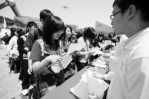 在世博会志愿者招募现场,许多青年人排队领取报名表。 殷立勤 摄